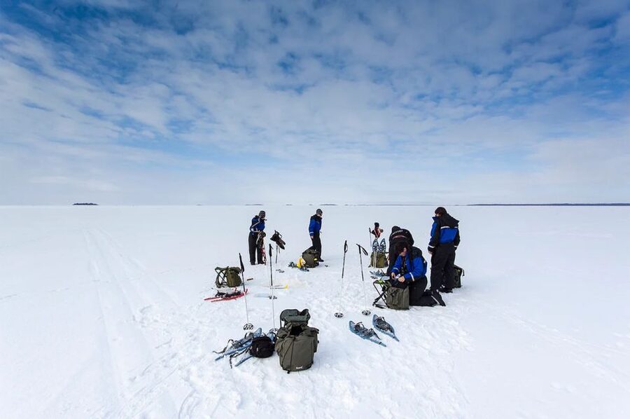 Lapland: Ice Fishing, Floating & BBQ Snow Adventure - A frozen lake, a fishing hole, and a floating suit