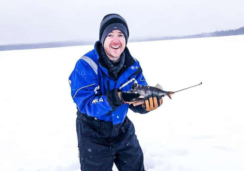 Snowshoe Trip for Ice Fishing in Saariselka - Drilling a hole in the frozen lake