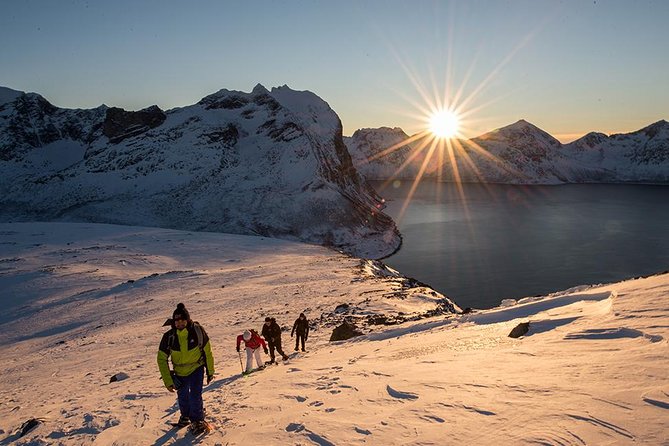 Snowshoers crossing a frozen valley at sunrise outside Tromso
